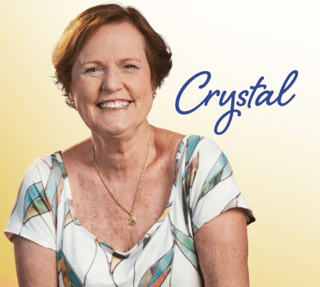 Photo of Crystal, smiling in a patterned, short-sleeved blouse.