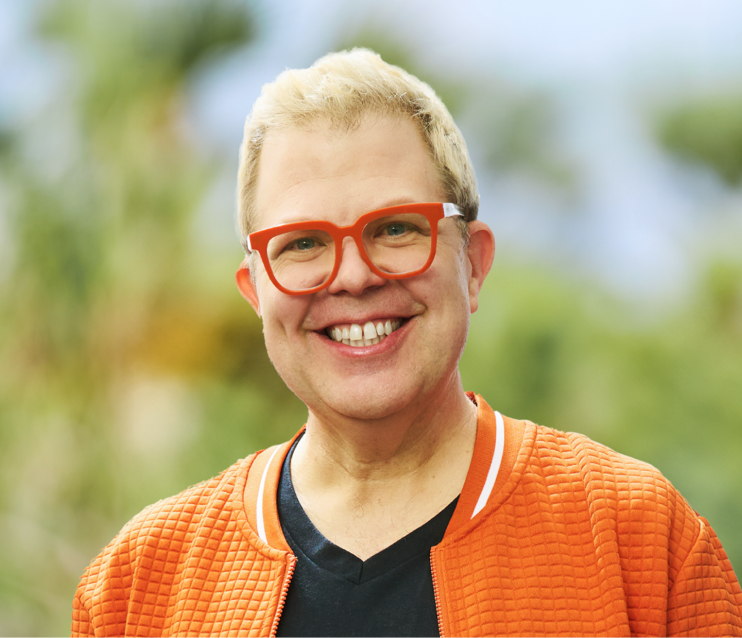 Brandon, a smiling man with bright orange glasses