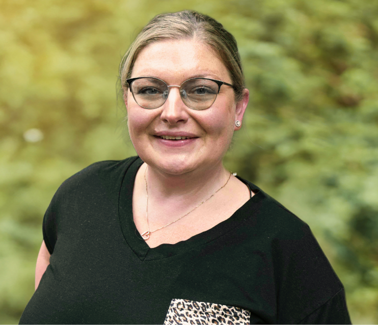 Sasha, a smiling woman wearing a black shirt with a leopard print detail