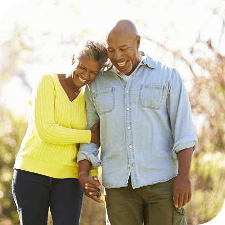 A smiling couple walks outdoors.