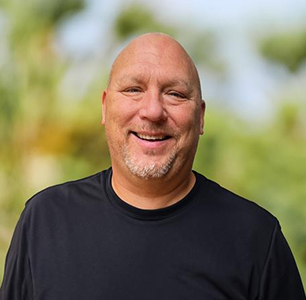 Head shot of Rick, a smiling man in a black shirt who lives with CIDP