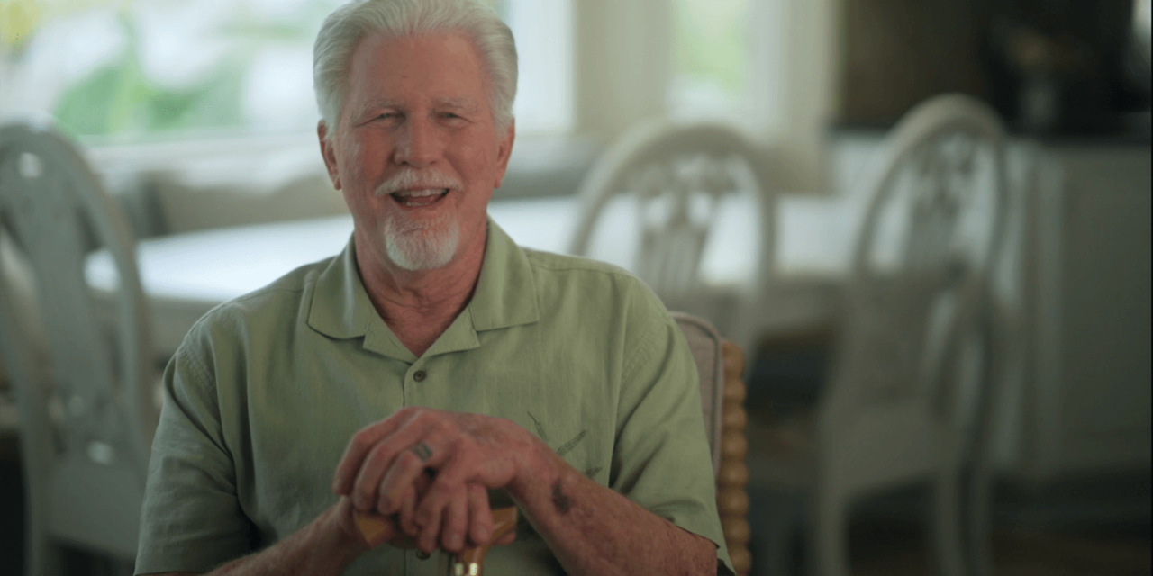 Wayne sitting down and smiling